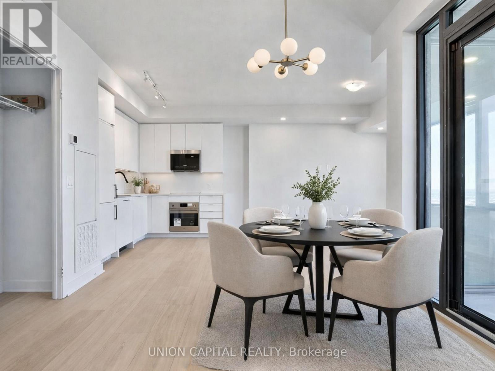 A dining room with a table set for four and a television mounted on the wall.