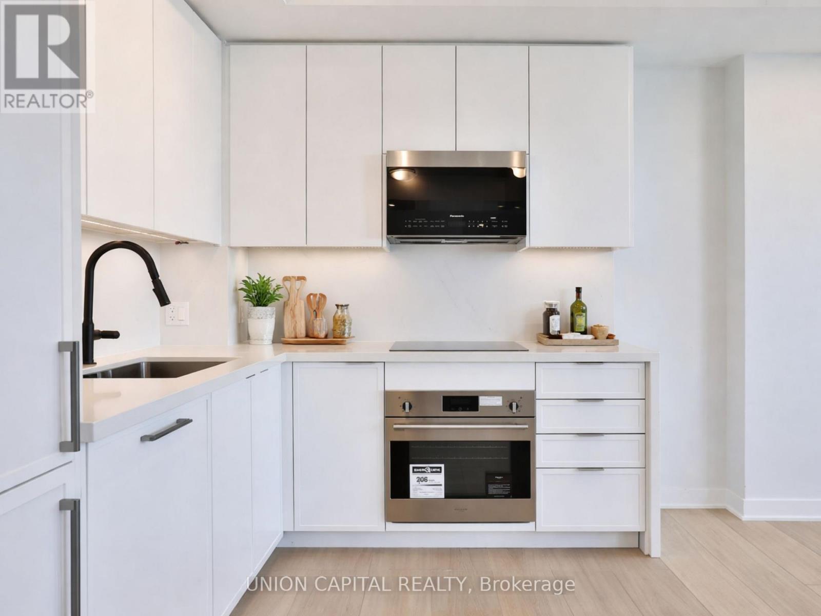 A kitchen with white cabinets and a stainless steel oven.