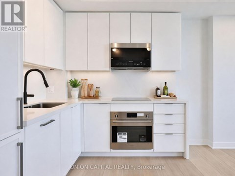A kitchen with white cabinets and a stainless steel oven.