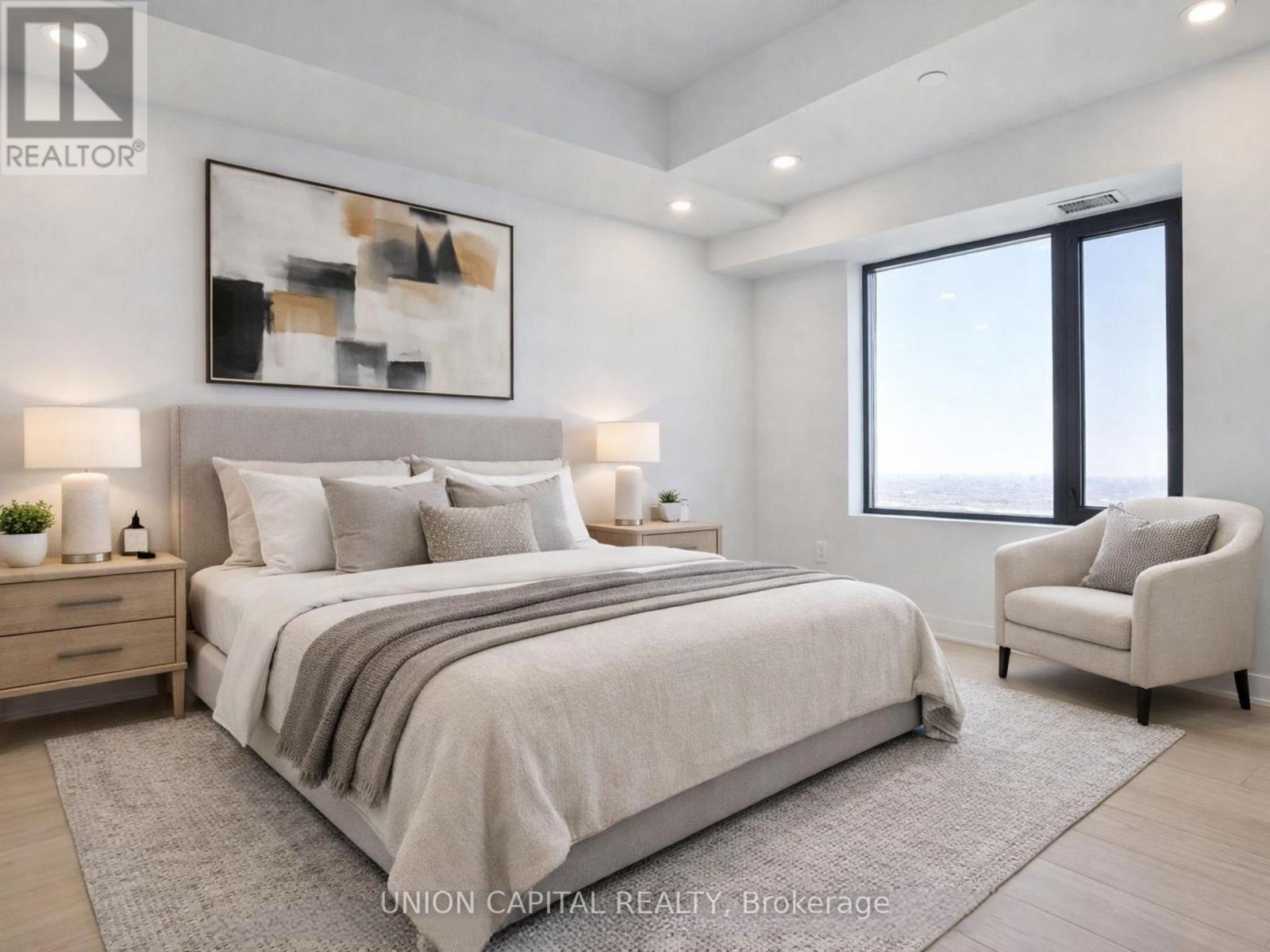 A bedroom with a large bed, a chair, and a painting on the wall.