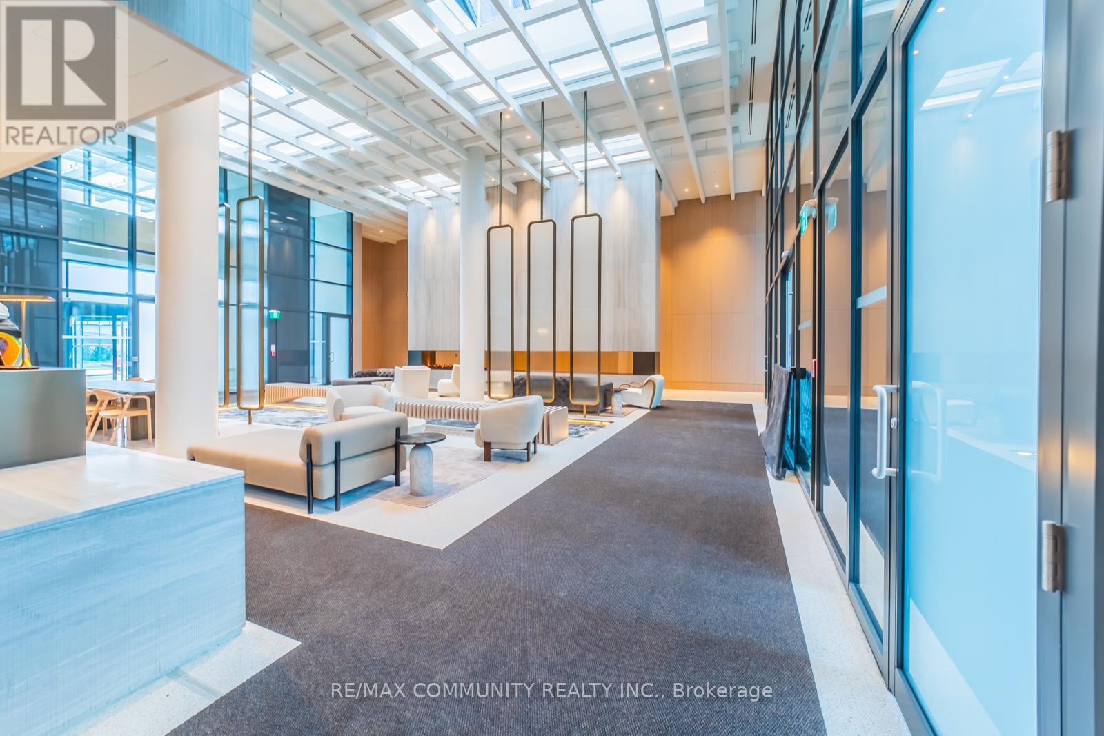 A spacious office lobby with a seating area and a glass wall.