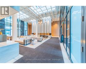A spacious office lobby with a seating area and a glass wall.