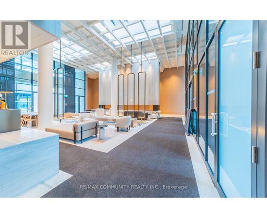 A spacious office lobby with a seating area and a glass wall.
