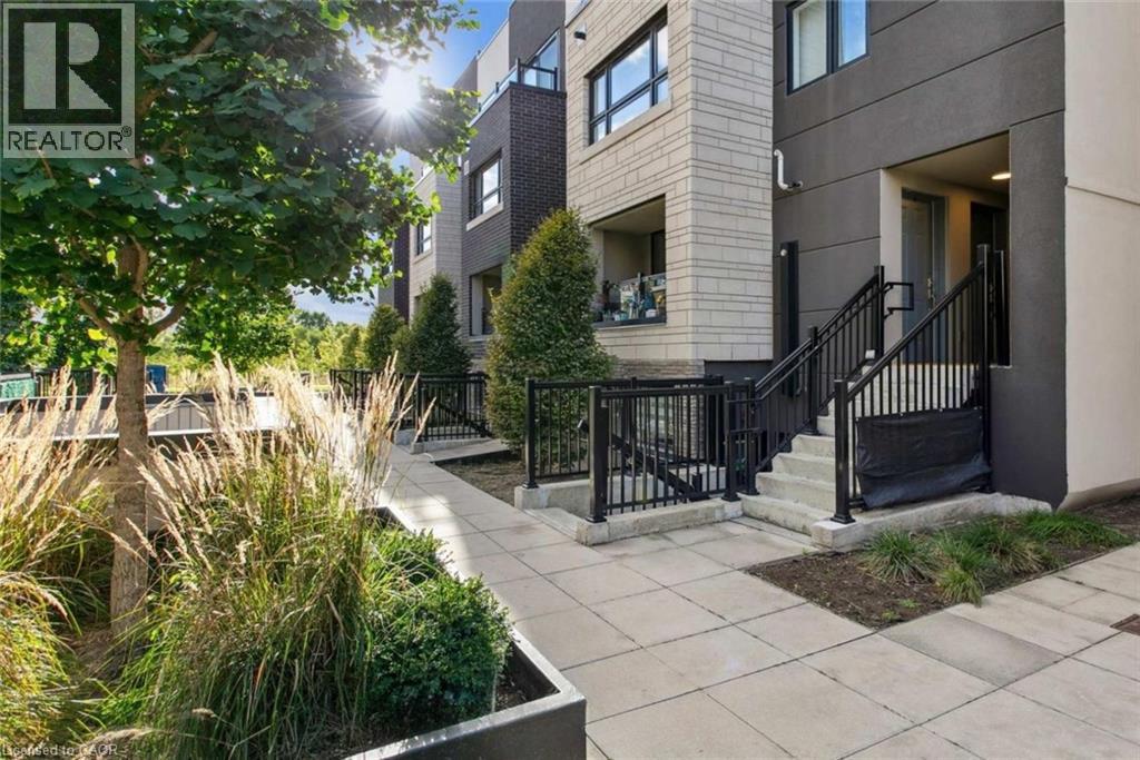 A sunny day at a modern apartment complex with a REALTOR® sign.