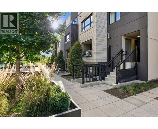 A sunny day at a modern apartment complex with a REALTOR® sign.
