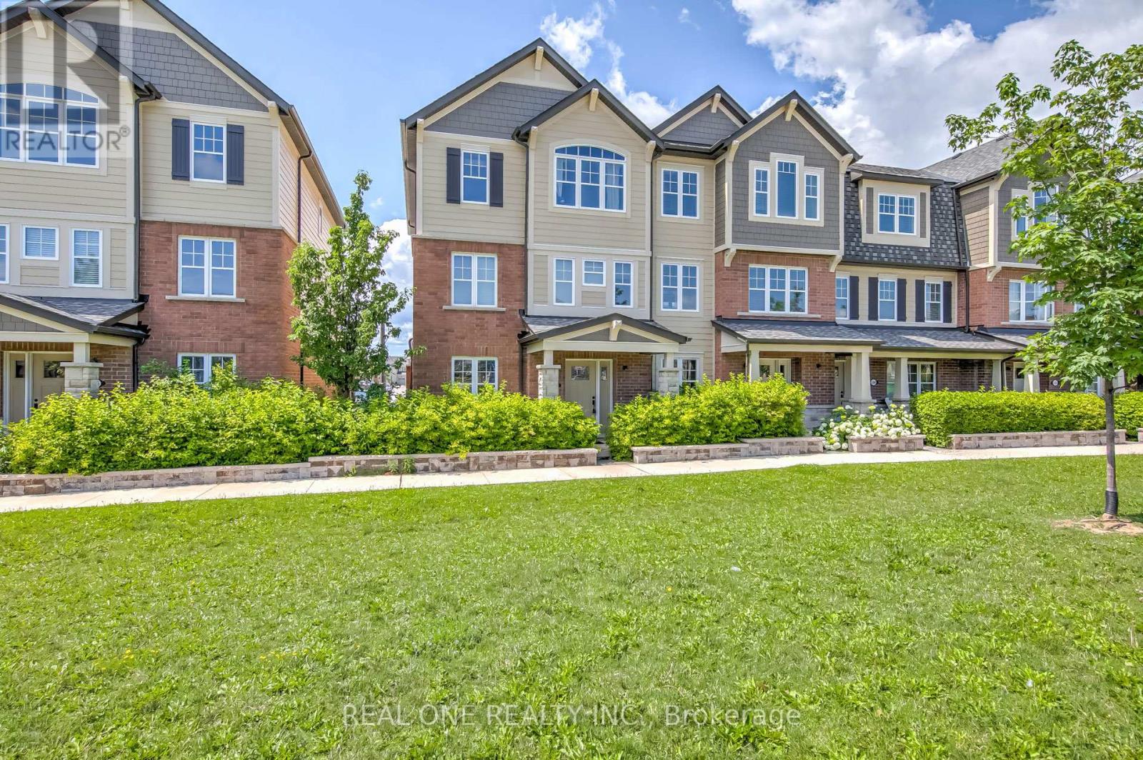 A row of townhouses with a grassy front yard.
