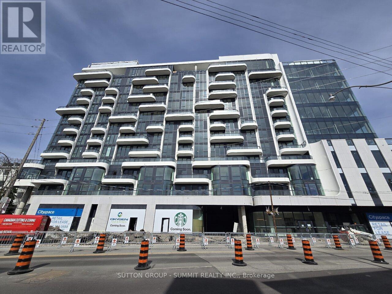 A large, modern building with a glass facade and a unique, geometric design.