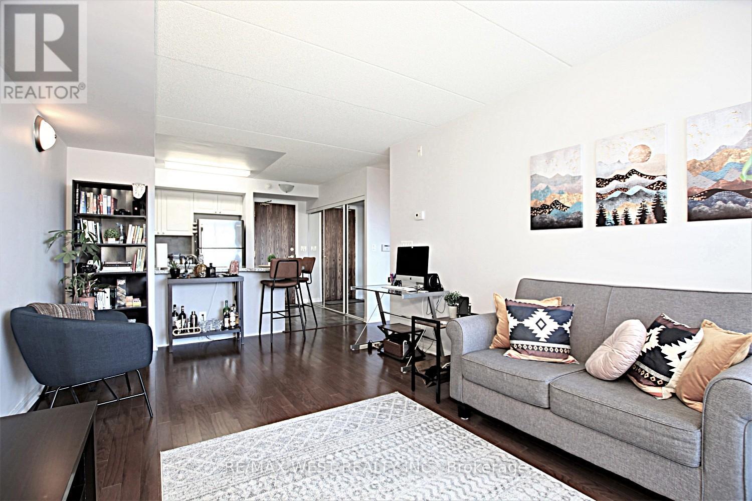 A living room with a grey couch and a white rug.