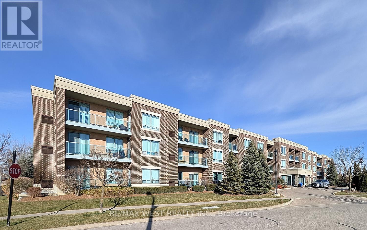 A multi-story apartment building with a stop sign in front.