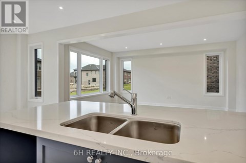 A modern kitchen with a stainless steel sink and white cabinets.