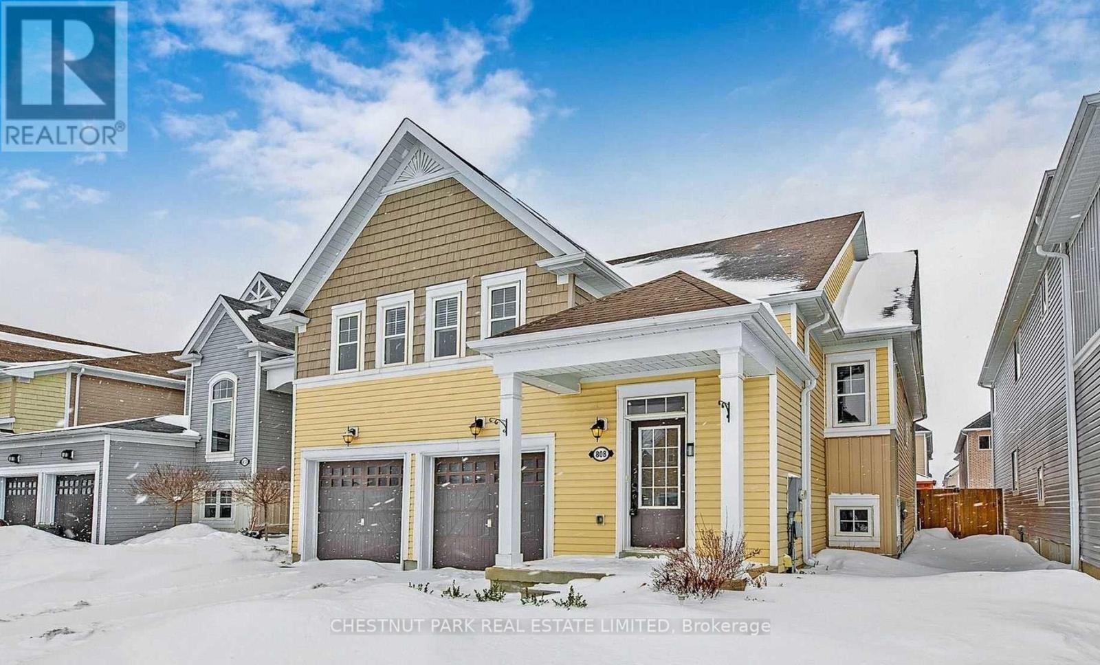 A house with a yellow front and a sign that says REALTOR.