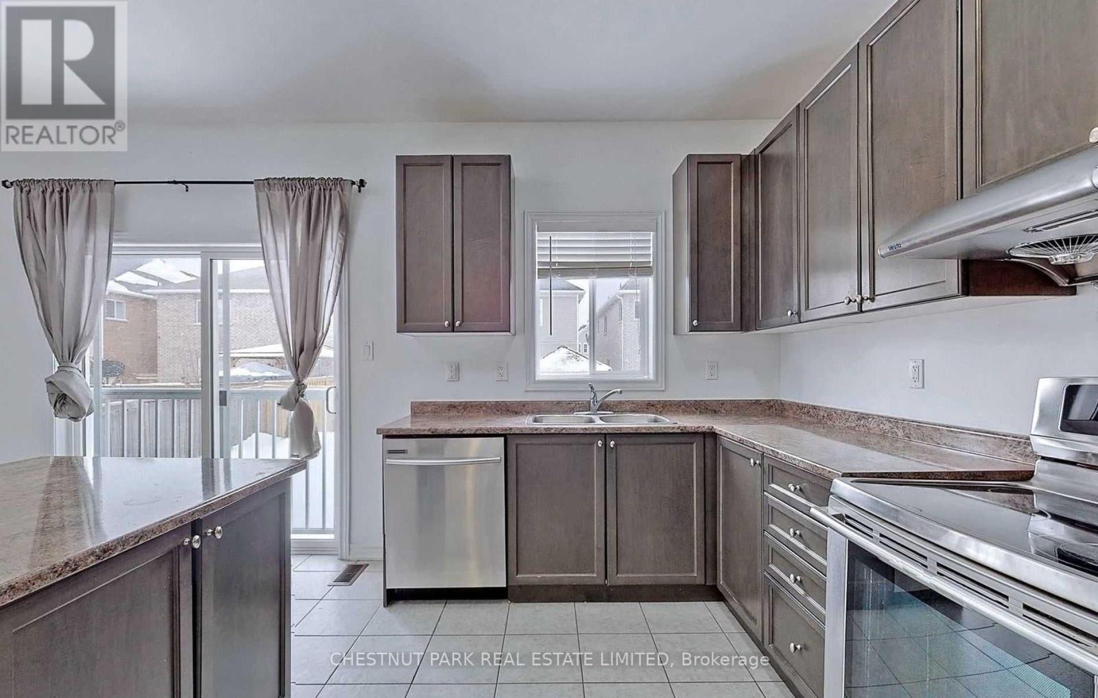 A kitchen with a refrigerator, oven, and cabinets.