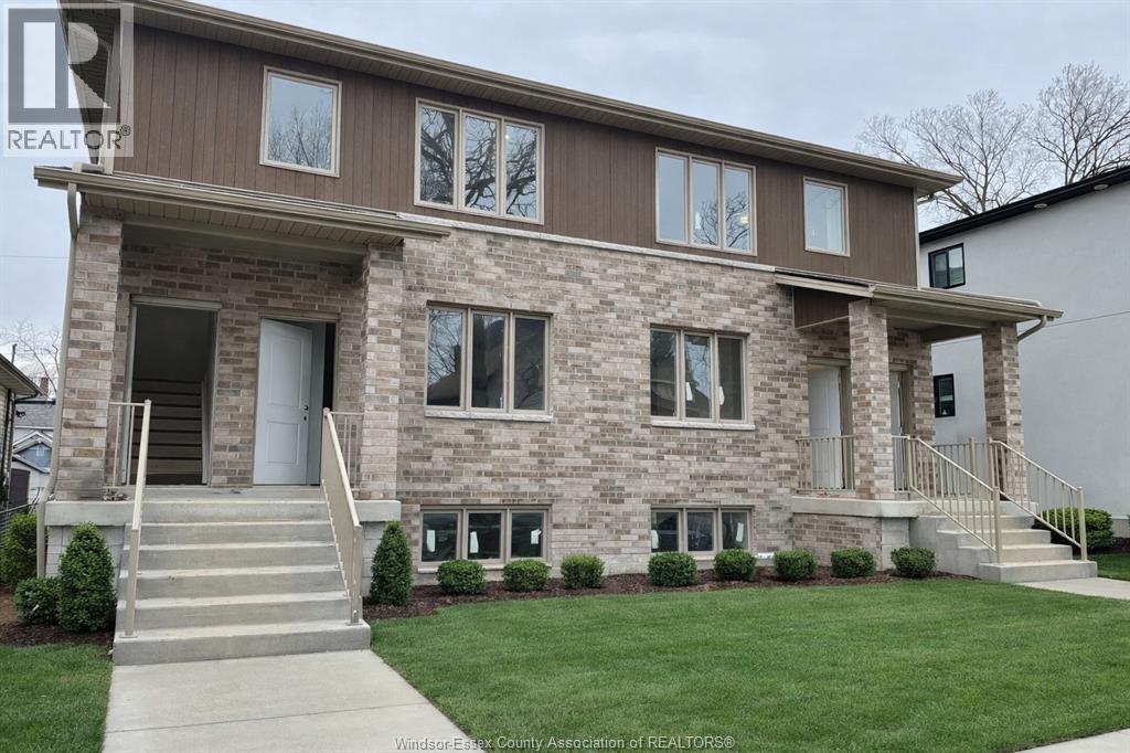 A house with a brown and beige exterior and a grey front door.