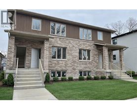 A house with a brown and beige exterior and a grey front door.