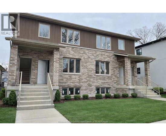 A house with a brown and beige exterior and a grey front door.