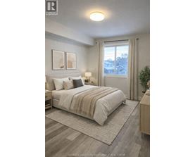 A well-lit bedroom with a large bed and a view of the outside through the window.
