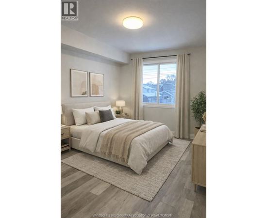 A well-lit bedroom with a large bed and a view of the outside through the window.
