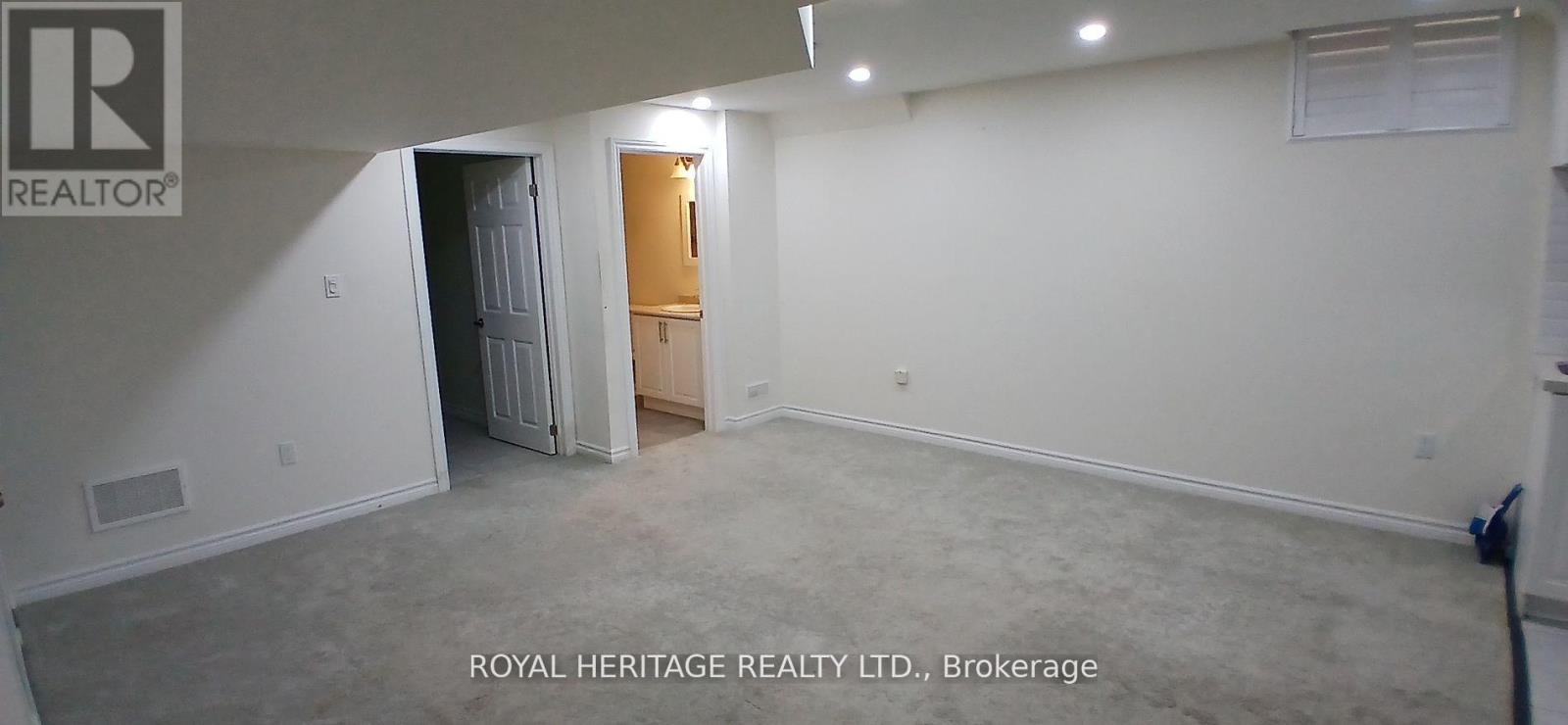 A spacious room with a doorway leading to another room.