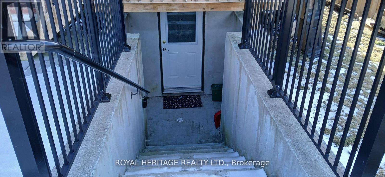 A stairway with a black railing and a white door.