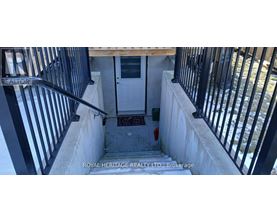 A stairway with a black railing and a white door.
