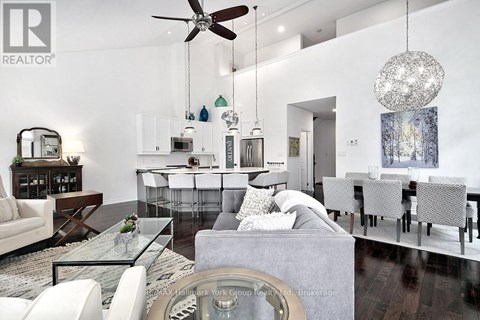 A modern living room with a glass table and white furniture.
