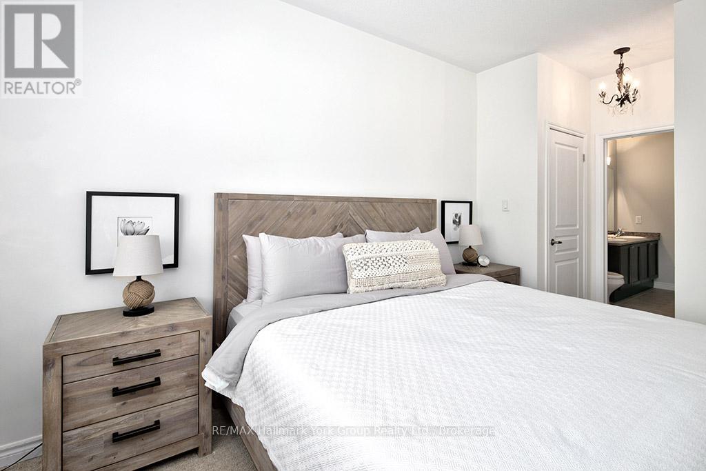 A bedroom with a large bed and a chandelier.
