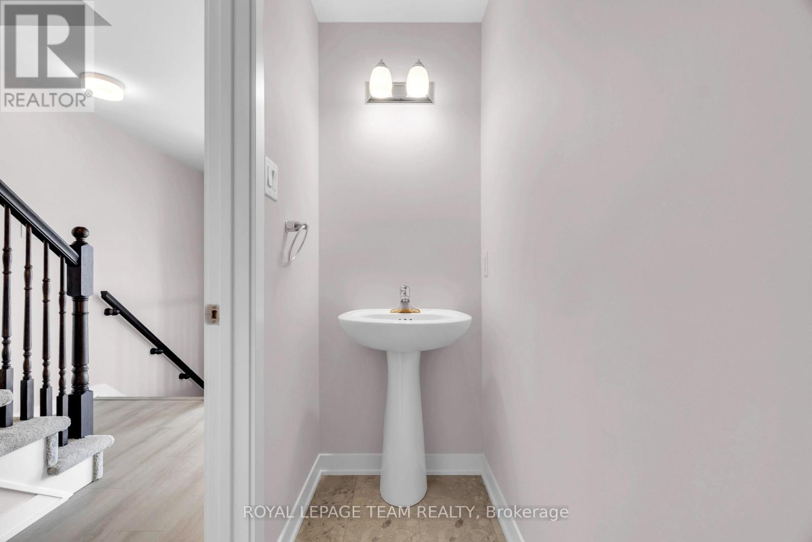A white pedestal sink in a small bathroom.
