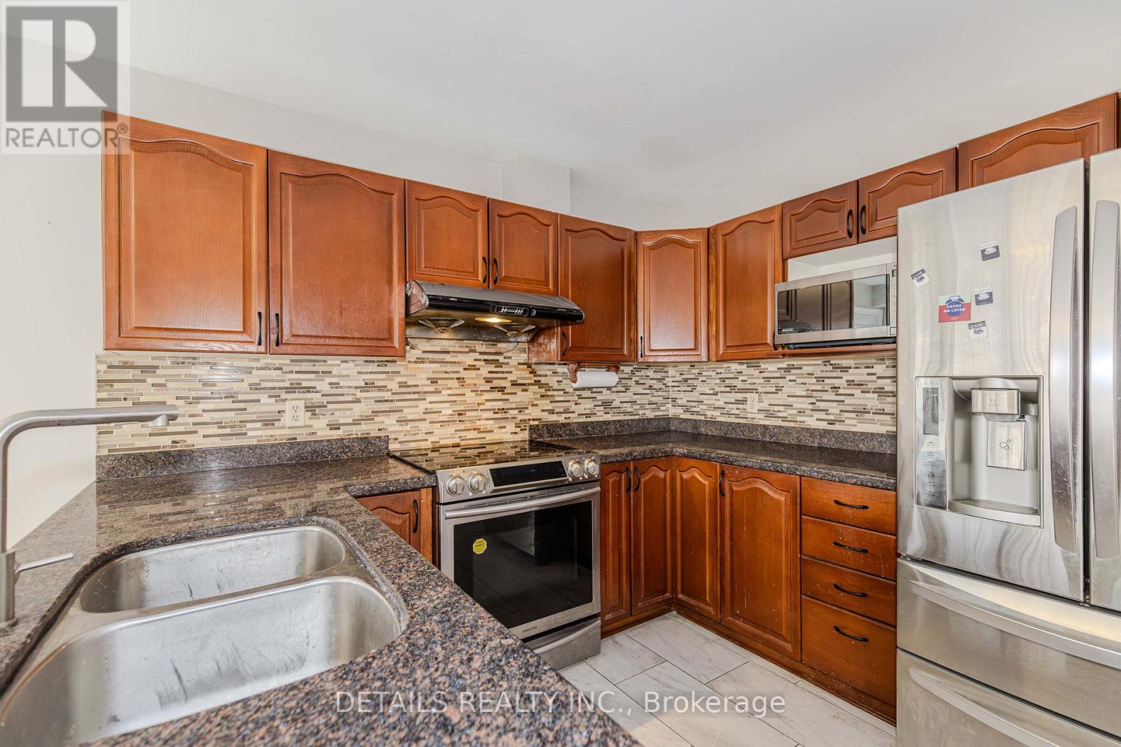 A kitchen with brown cabinets and a stainless steel refrigerator.