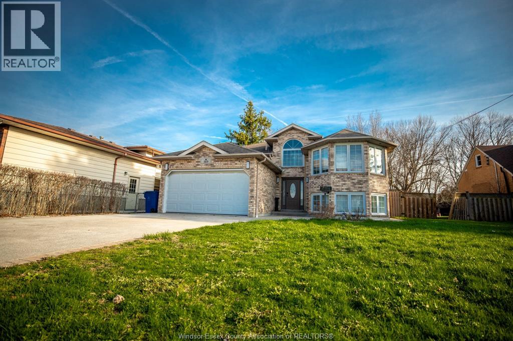 A large house with a garage is surrounded by a grassy area.
