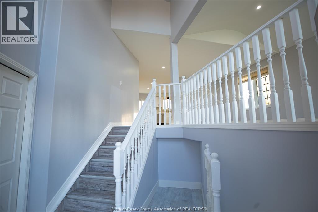 A staircase with white railings and a light blue carpet.