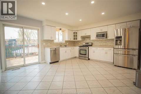 A kitchen with white cabinets and appliances is on the market.