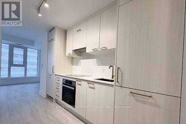 A modern kitchen with white cabinets and a stainless steel oven.