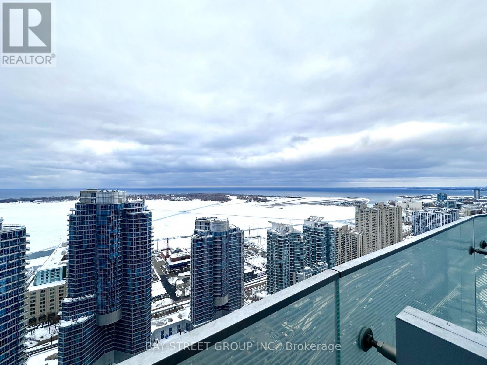 A view of a cityscape from a high-rise building with a glass railing.