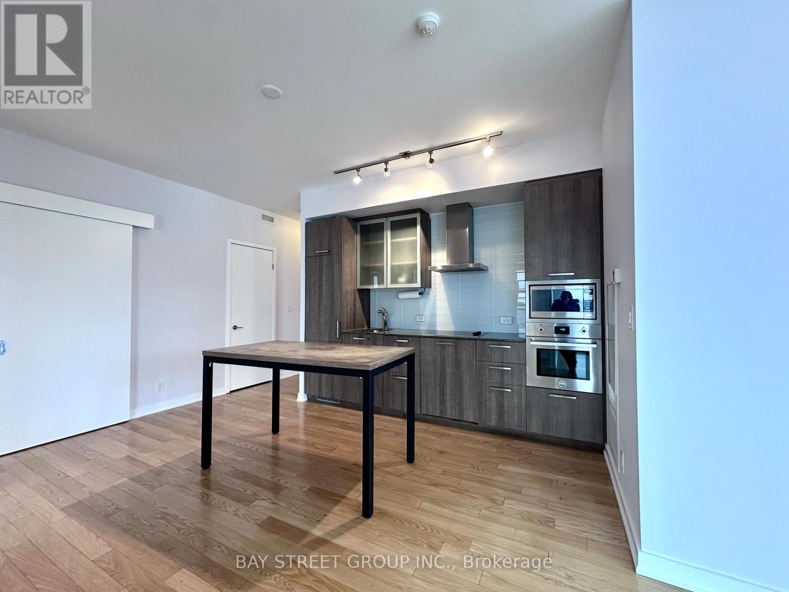 A modern kitchen with a dining table in the middle.
