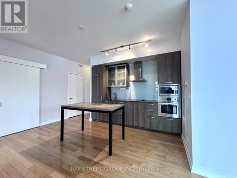 A modern kitchen with a dining table in the middle.