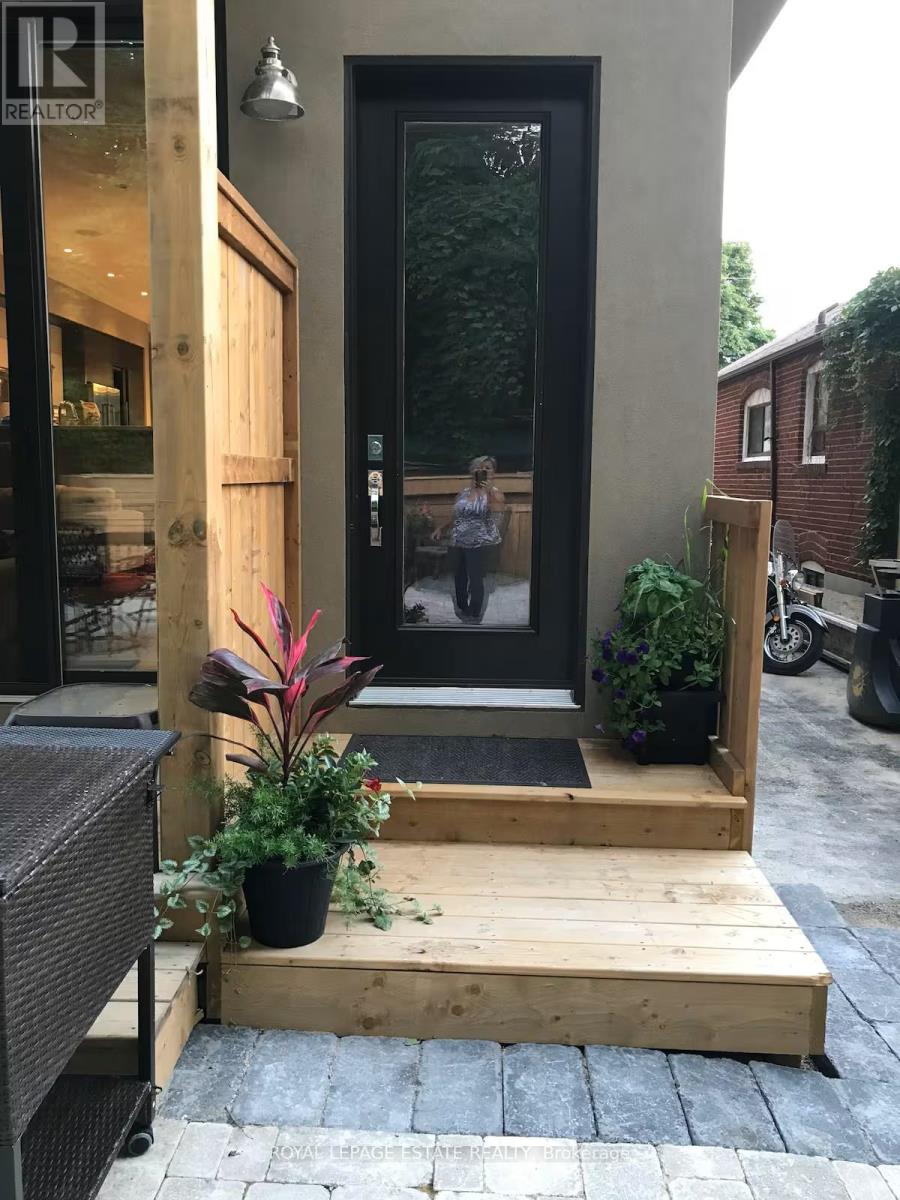 A woman stands in the doorway of a building with a sign that says REALTOR.