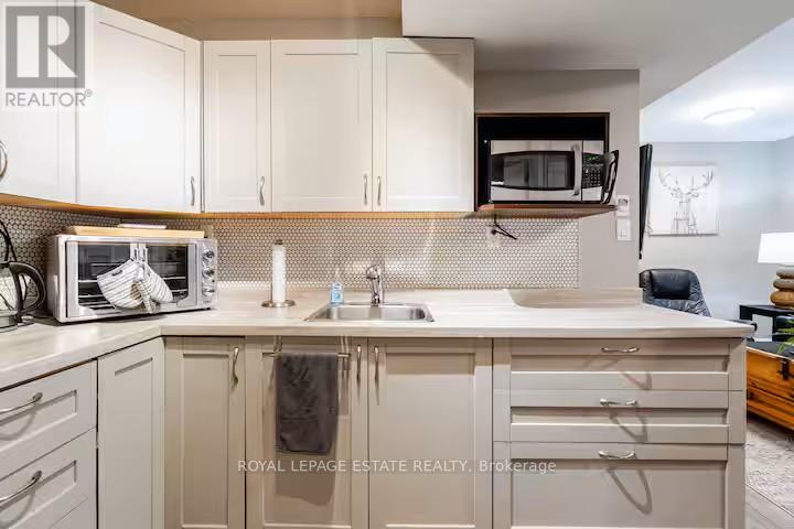 A kitchen with white cabinets and a microwave on the counter.