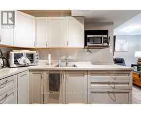 A kitchen with white cabinets and a microwave on the counter.
