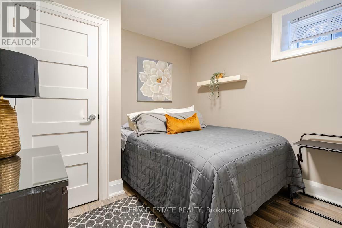 A bedroom with a bed, a lamp, and a picture on the wall.