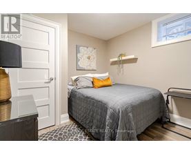 A bedroom with a bed, a lamp, and a picture on the wall.