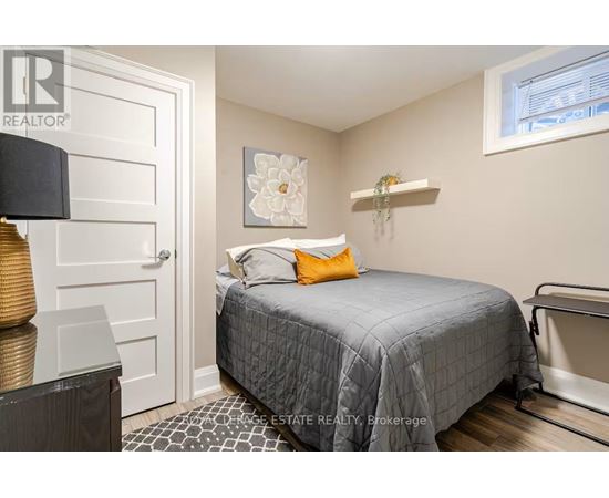 A bedroom with a bed, a lamp, and a picture on the wall.
