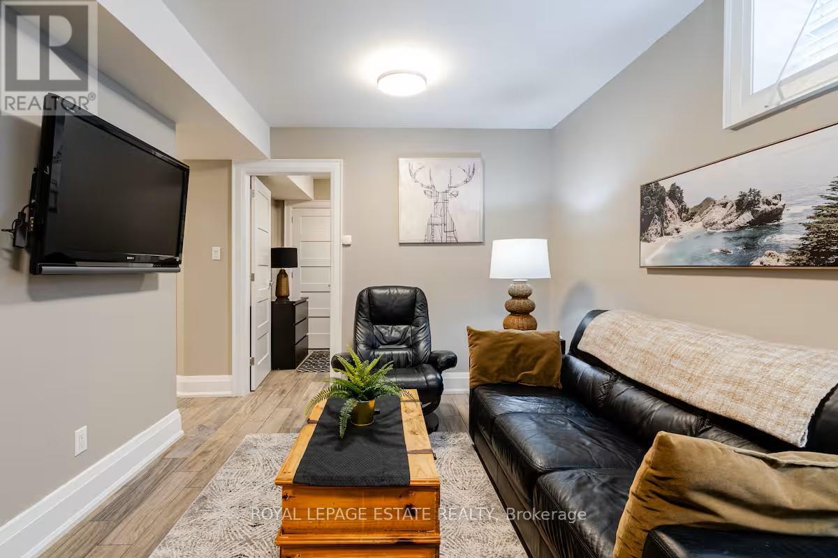 A living room with a black leather couch and a wooden coffee table.