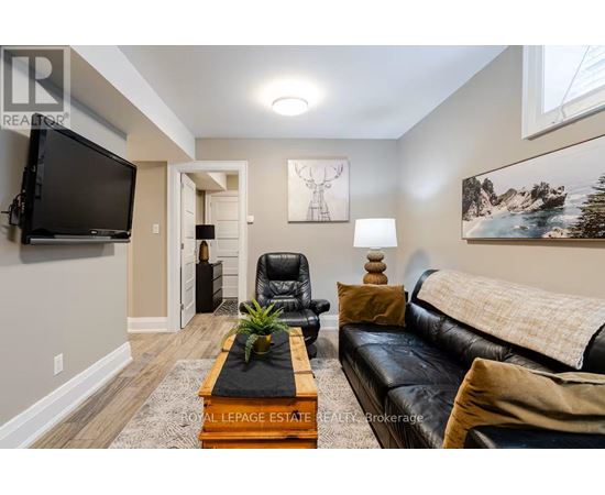 A living room with a black leather couch and a wooden coffee table.