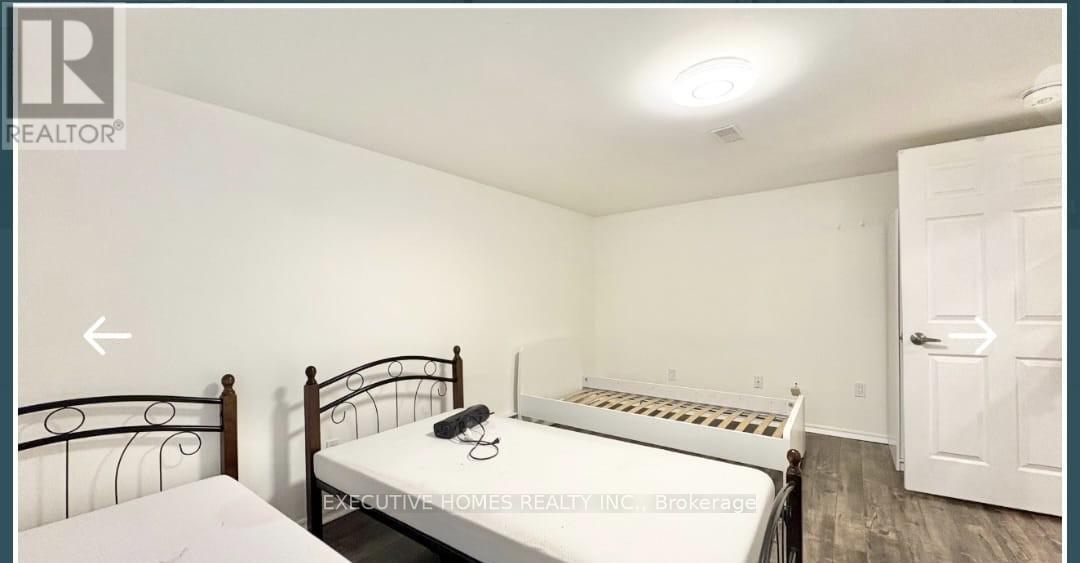 A bedroom with a bed, a nightstand, and a door.