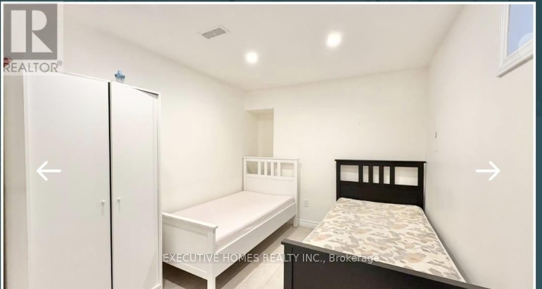 A bedroom with a white bed and a black bed.
