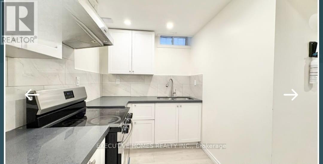 A kitchen with a stove top oven and a range hood.
