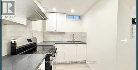 A kitchen with a stove top oven and a range hood.