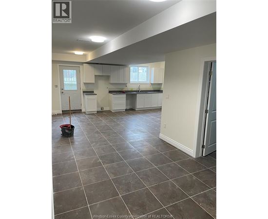 A kitchen and living room with tile flooring and white walls.