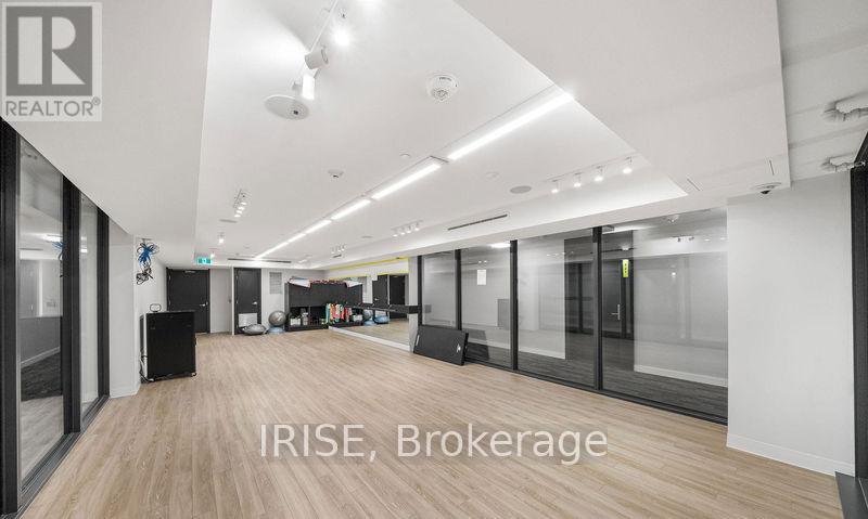 A spacious office with wood flooring and glass walls.
