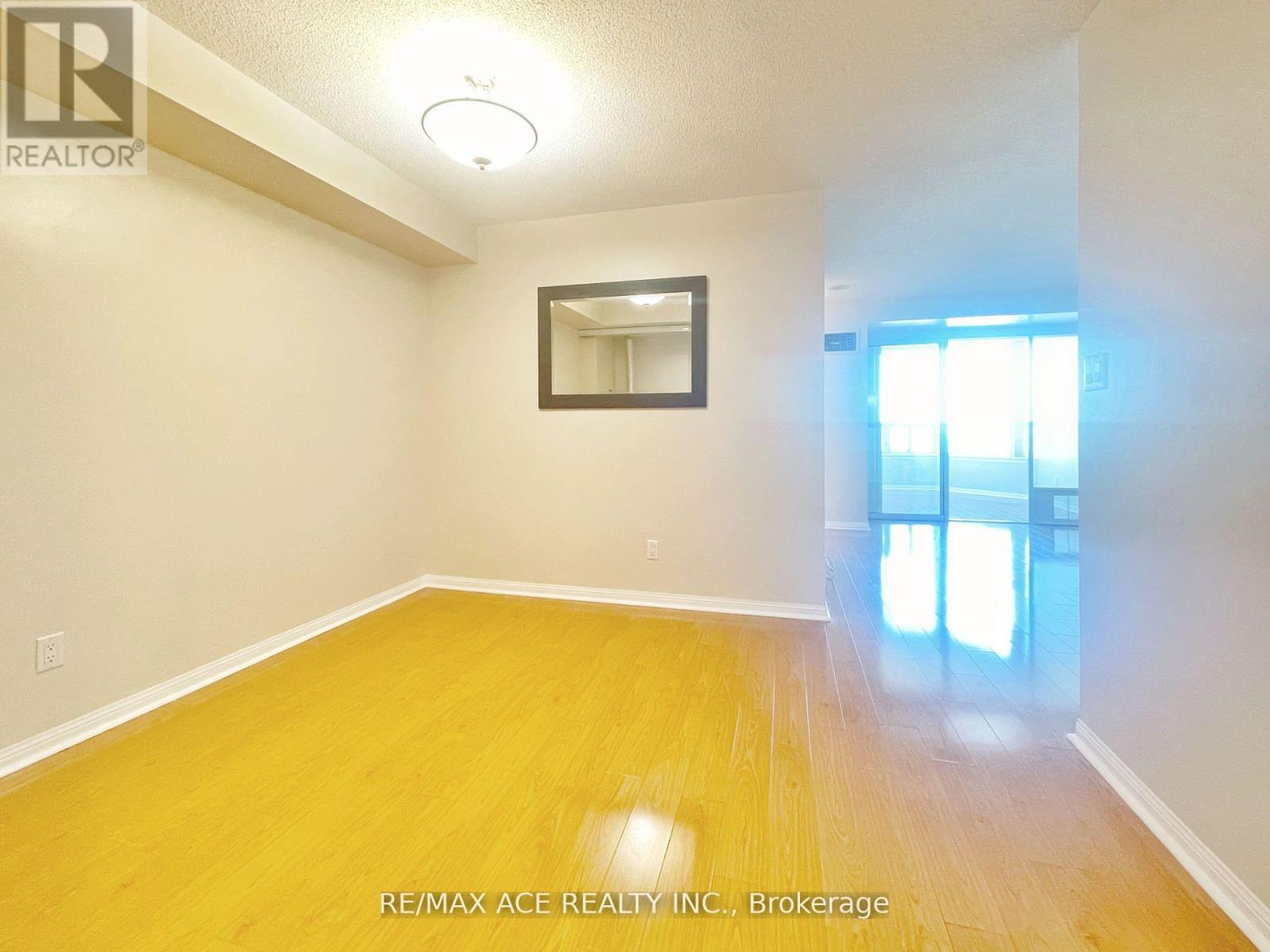 A room with a wooden floor and a mirror on the wall.